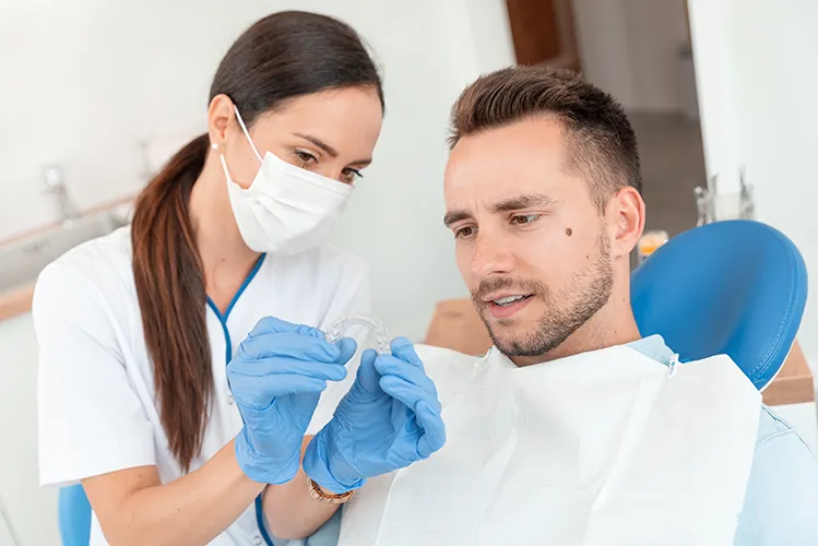 Dentist showing patient a pair of invisalign aligners - Harmony Family Dentistry in Vancouver WA