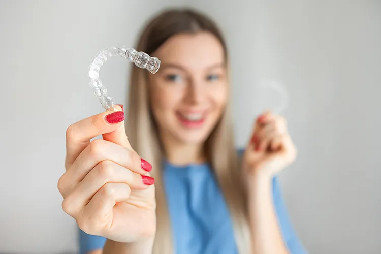 Person holding pair of Invisalign® aligners - Harmony Family Dentistry in Vancouver WA