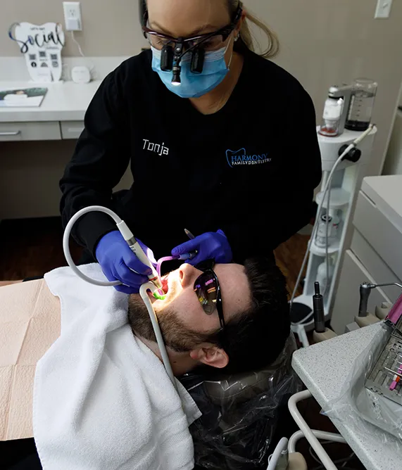 Dental assistant cleaning a patient's teeth - Harmony Family Dentistry in Vancouver WA